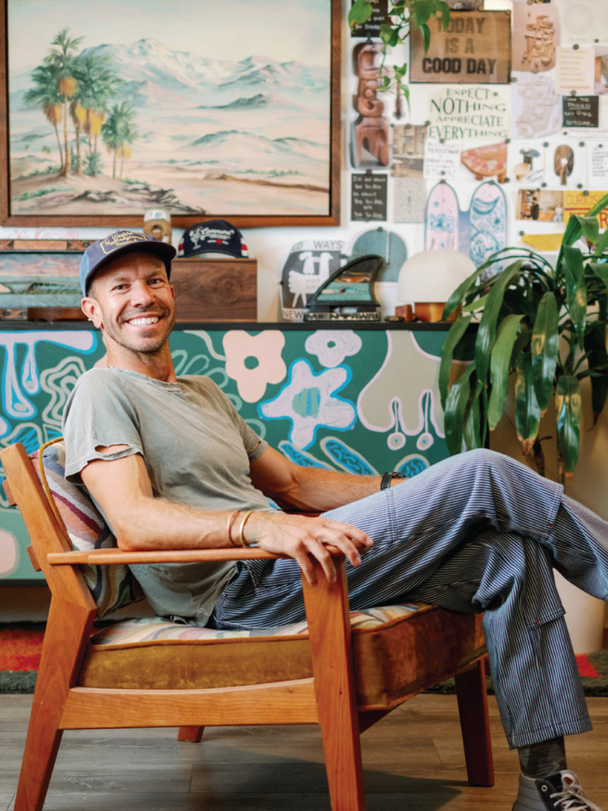 Sean Woolsey seated in a handmade wooden lounge chair in his studio